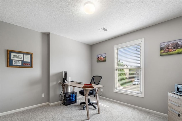 carpeted office space with a textured ceiling, visible vents, and baseboards