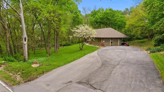 606 W Red Bridge Rd, Kansas City, MO 64114 - view of front of property featuring driveway, a wooded view, a front lawn, and a garage
