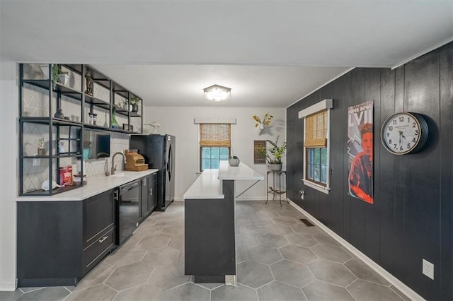 606 W Red Bridge Rd, Kansas City, MO 64114 - kitchen featuring black appliances, light countertops, dark cabinetry, open shelves, and wood walls
