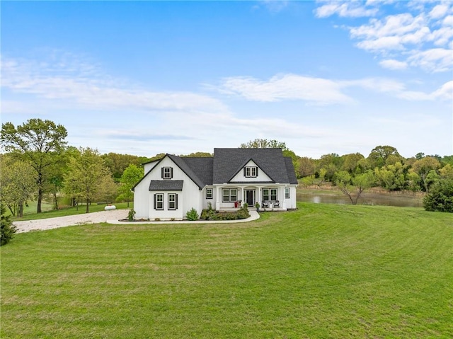 modern farmhouse with a porch, a water view, driveway, and a front lawn