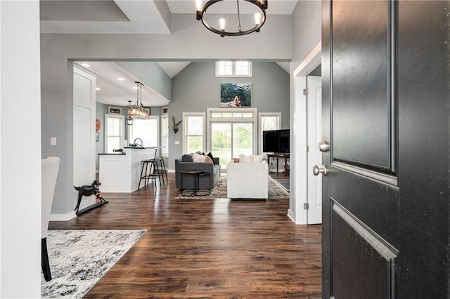 entryway with dark wood finished floors, a chandelier, and a wealth of natural light