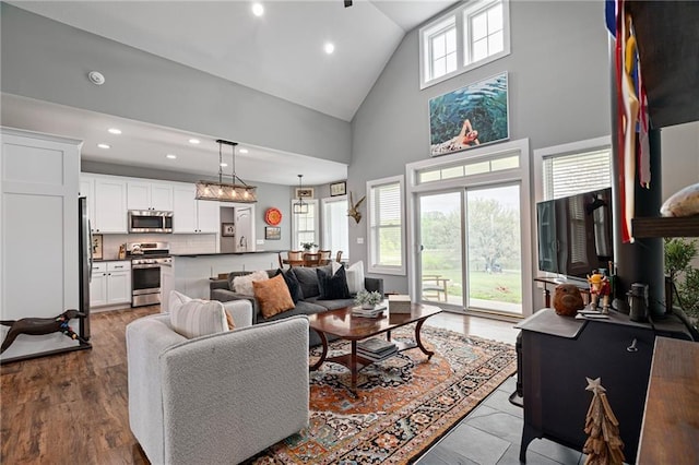 living room with recessed lighting and high vaulted ceiling