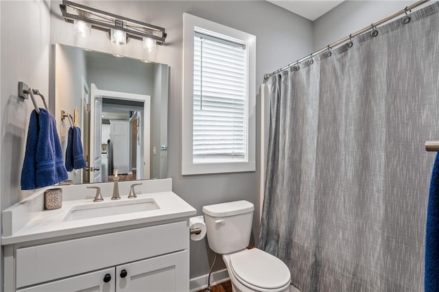 bathroom with vanity, curtained shower, and toilet