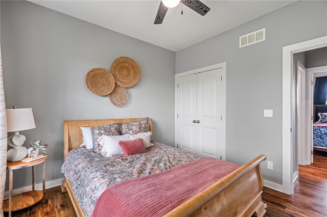 bedroom featuring baseboards, visible vents, dark wood finished floors, and a closet