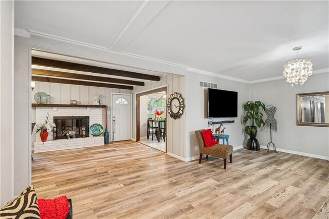 - living room with visible vents, wood finished floors, a fireplace, baseboards, and a chandelier