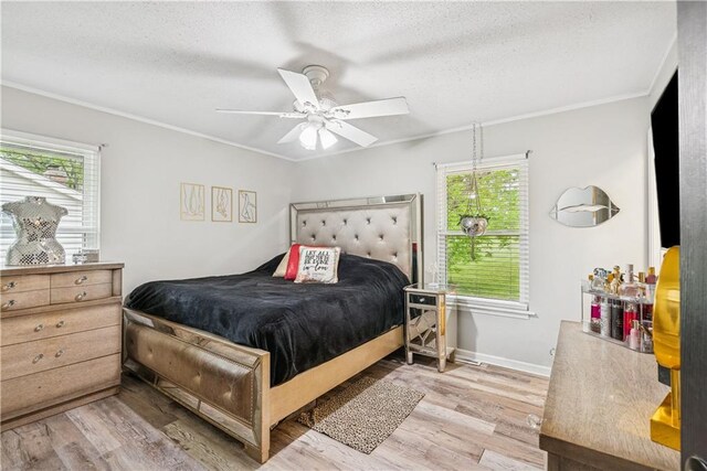  - bedroom with ceiling fan, a textured ceiling, baseboards, wood finished floors, and ornamental molding