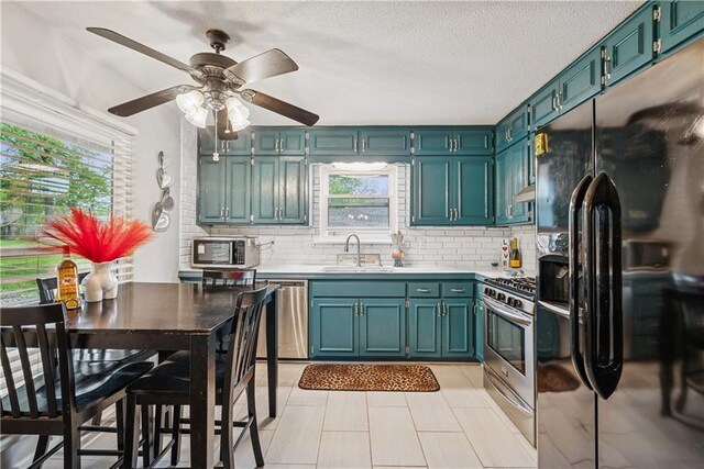  - kitchen with backsplash, stainless steel appliances, a sink, and light countertops