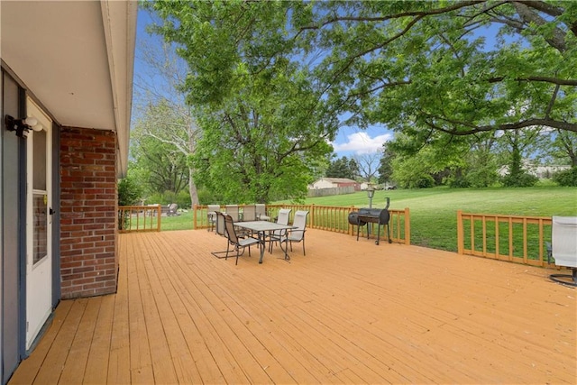  - wooden terrace featuring a lawn and outdoor dining area