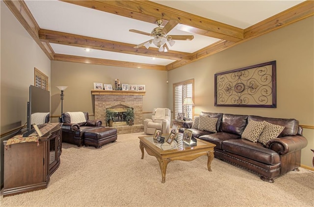 living area with ceiling fan, a brick fireplace, carpet floors, and beam ceiling