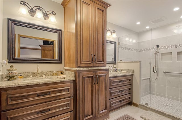 bathroom with a sink, two vanities, a stall shower, and tile patterned floors