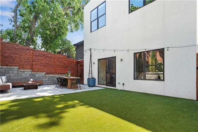 4727 Liberty St, Kansas City, MO 64112 - rear view of property featuring a fire pit, stucco siding, and a patio area