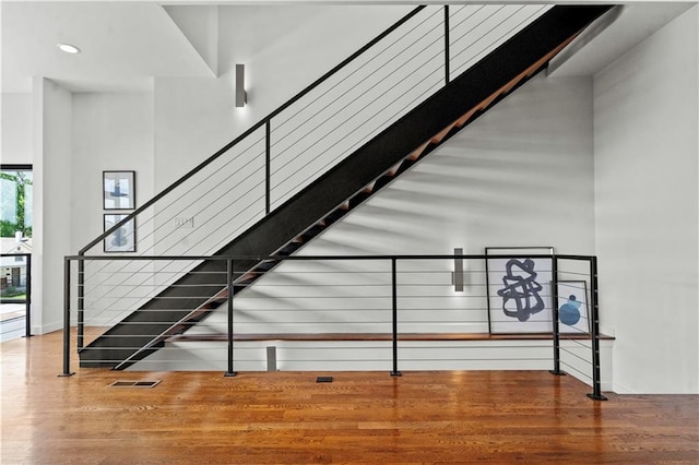 4727 Liberty St, Kansas City, MO 64112 - staircase featuring wood finished floors, baseboards, and recessed lighting