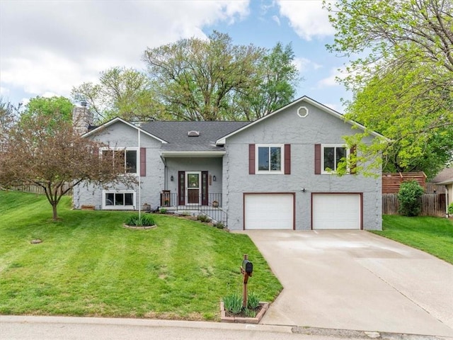 raised ranch featuring a garage, fence, a front yard, a chimney, and concrete driveway