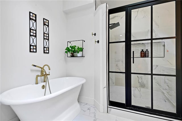 bathroom with marble look tiles, a stall shower, a soaking tub, and baseboards