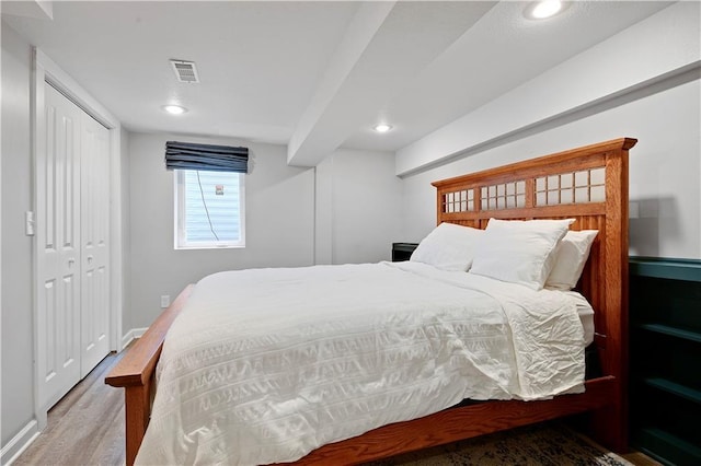 bedroom featuring wood finished floors, recessed lighting, a closet, and baseboards