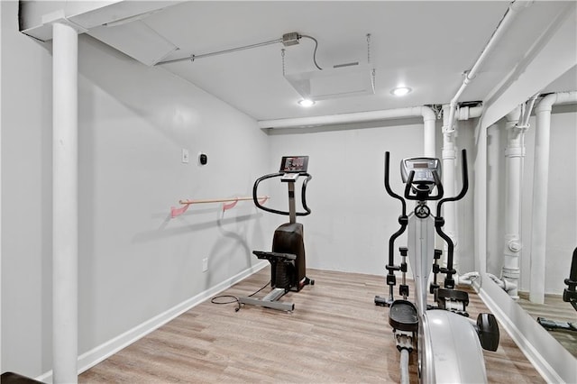 exercise room featuring wood finished floors and baseboards