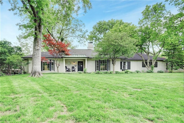 view of front of home with a chimney and a front yard
