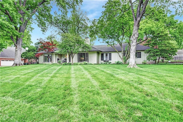 back of property featuring a lawn, board and batten siding, and a chimney