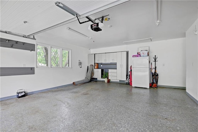 garage featuring freestanding refrigerator, a garage door opener, and baseboards
