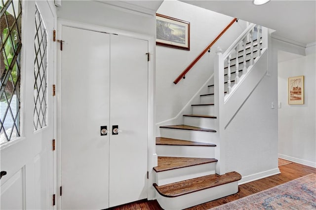 stairway featuring wood finished floors and baseboards
