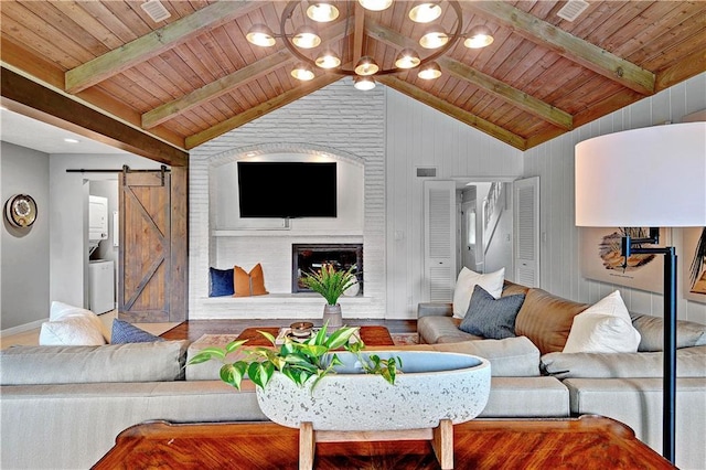living area featuring a barn door, baseboards, a fireplace, and wooden ceiling