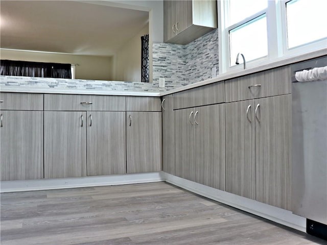 3417 Jackson Ave, Kansas City, MO 64128 - interior space with light countertops, gray cabinets, light wood finished floors, and backsplash