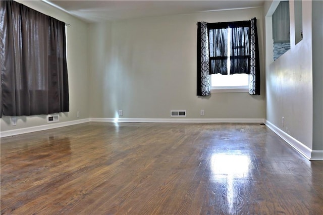 3417 Jackson Ave, Kansas City, MO 64128 - spare room with baseboards, dark wood-style floors, and visible vents