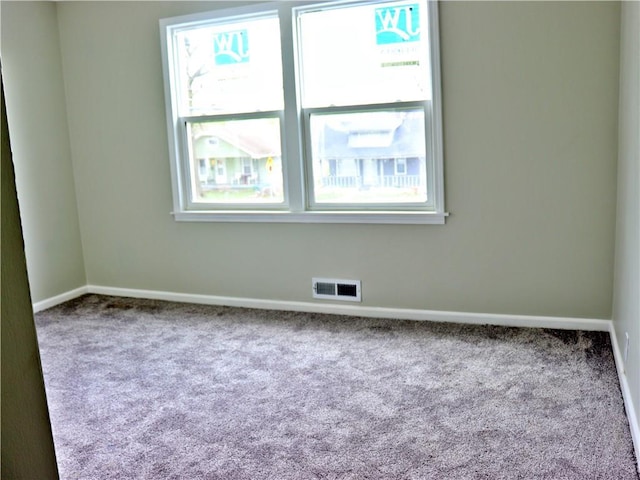 3417 Jackson Ave, Kansas City, MO 64128 - carpeted spare room featuring a healthy amount of sunlight, baseboards, and visible vents