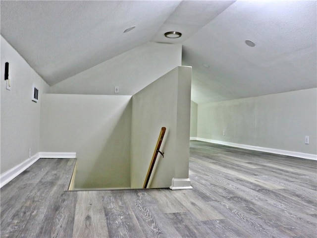3417 Jackson Ave, Kansas City, MO 64128 - bonus room with baseboards, wood finished floors, vaulted ceiling, and visible vents