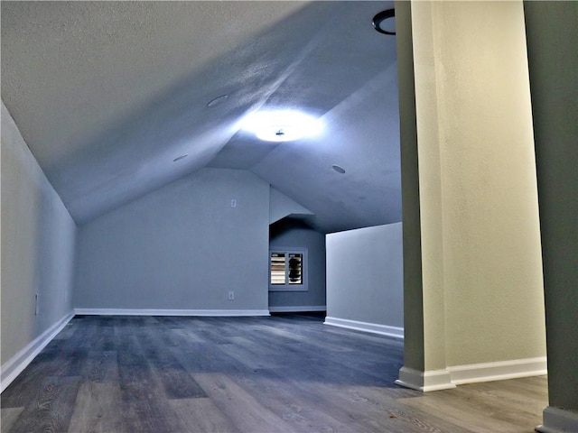 3417 Jackson Ave, Kansas City, MO 64128 - bonus room featuring baseboards, wood finished floors, and vaulted ceiling
