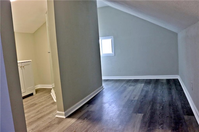 3417 Jackson Ave, Kansas City, MO 64128 - bonus room with baseboards, wood finished floors, and lofted ceiling