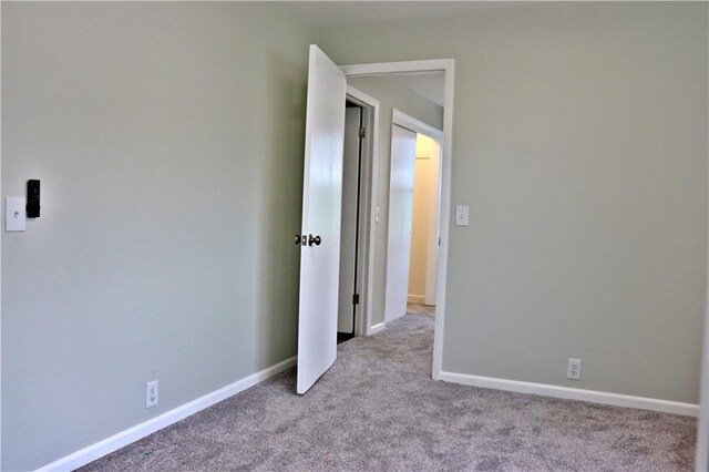 3417 Jackson Ave, Kansas City, MO 64128 - carpeted empty room with baseboards