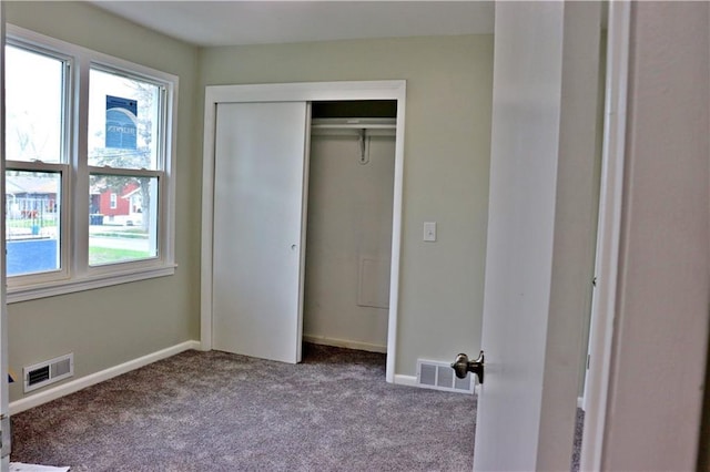 3417 Jackson Ave, Kansas City, MO 64128 - unfurnished bedroom featuring carpet flooring, visible vents, and multiple windows