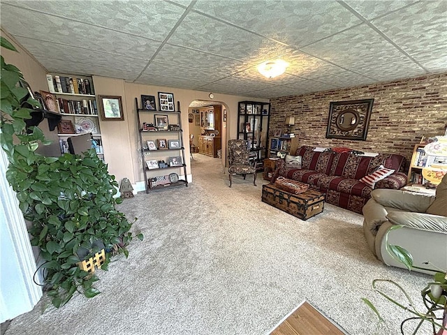 109 S State Route F, Garden City, MO 64747 - living room featuring arched walkways, brick wall, and carpet