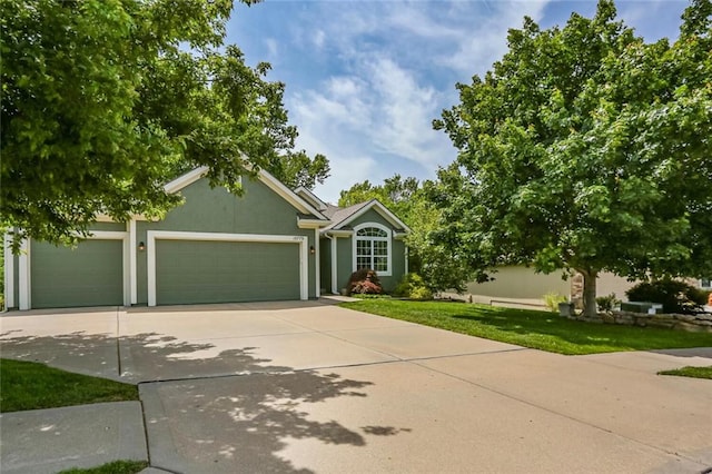 view of front of home with a garage, concrete driveway, stucco siding, and a front yard