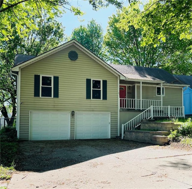 view of front of property with a porch, an attached garage, and driveway