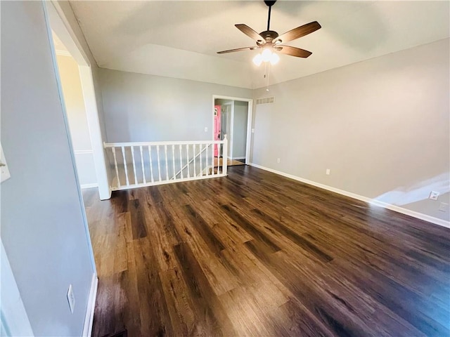 empty room with baseboards, a ceiling fan, wood finished floors, and visible vents