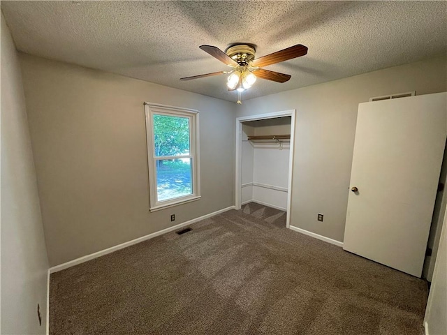 unfurnished bedroom featuring a textured ceiling, visible vents, baseboards, a closet, and carpet