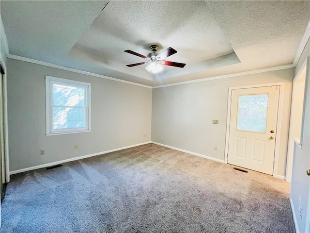 carpeted empty room featuring a raised ceiling, ceiling fan, a textured ceiling, and visible vents