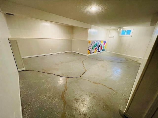 basement featuring visible vents and a textured ceiling