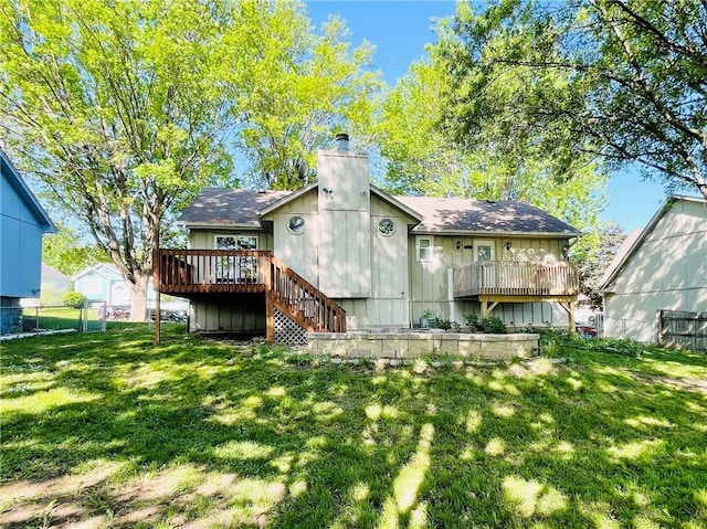 back of property featuring a wooden deck, fence, a chimney, a yard, and stairway