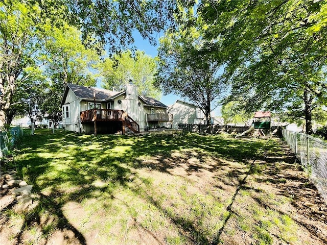 view of yard featuring a fenced backyard, a wooden deck, and a playground