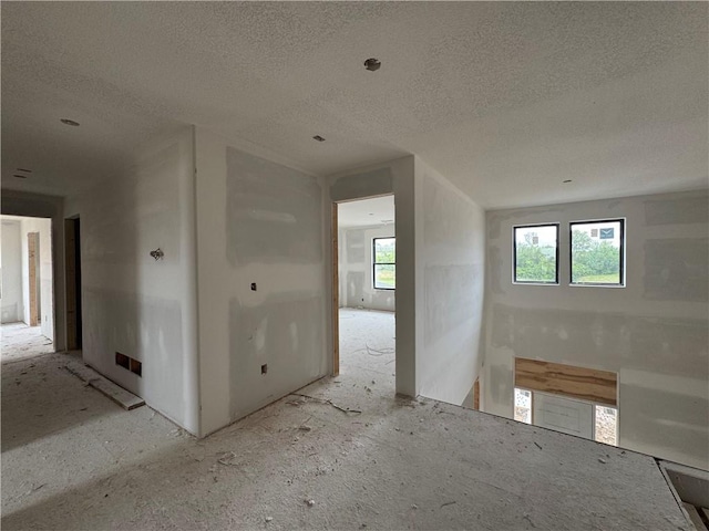 13610 NE 114th Pl, Kearney, MO 64060 - empty room featuring a textured ceiling and plenty of natural light
