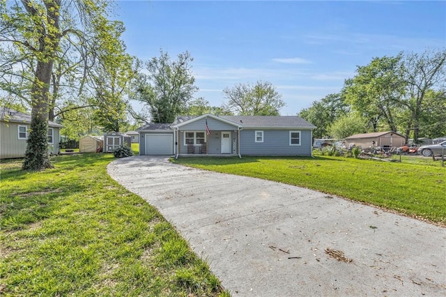 single story home featuring a front lawn, driveway, an outbuilding, an attached garage, and a storage shed