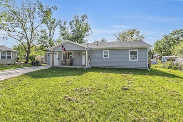 ranch-style home featuring a front lawn and concrete driveway
