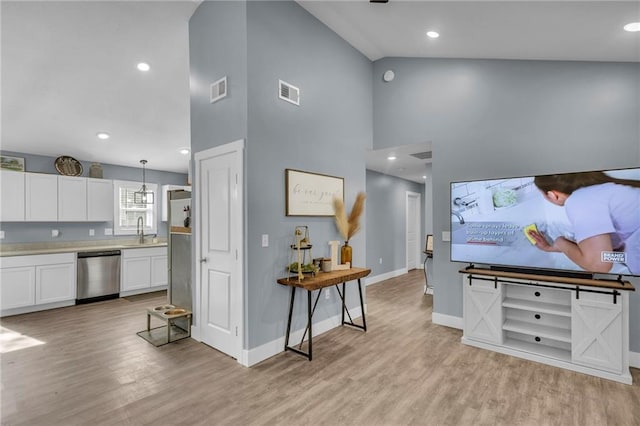 living room featuring recessed lighting, baseboards, light wood-type flooring, and visible vents
