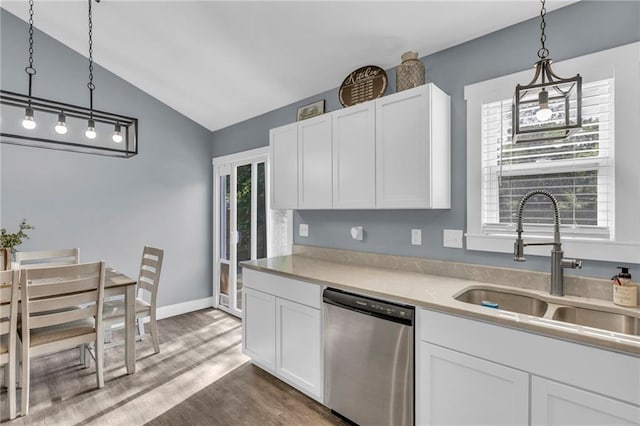 kitchen with a sink, stainless steel dishwasher, white cabinetry, and lofted ceiling