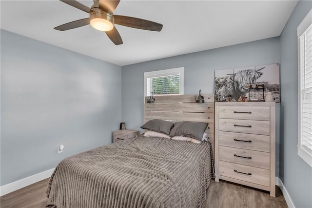 bedroom with baseboards, ceiling fan, and wood finished floors