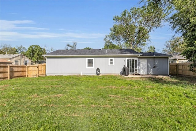 rear view of property with a lawn and a fenced backyard