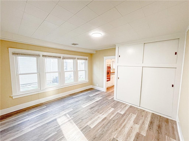unfurnished living room featuring light wood-style floors, baseboards, and visible vents